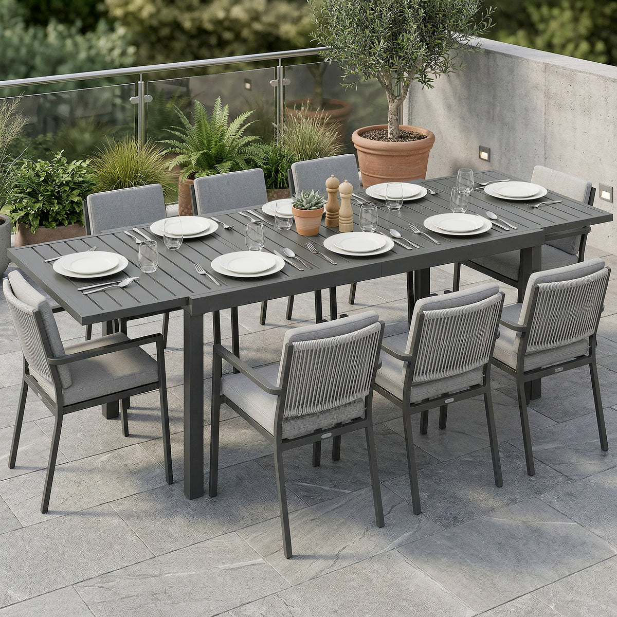 Dark grey slatted outdoor extending dining table with thick legs and tabletop rails