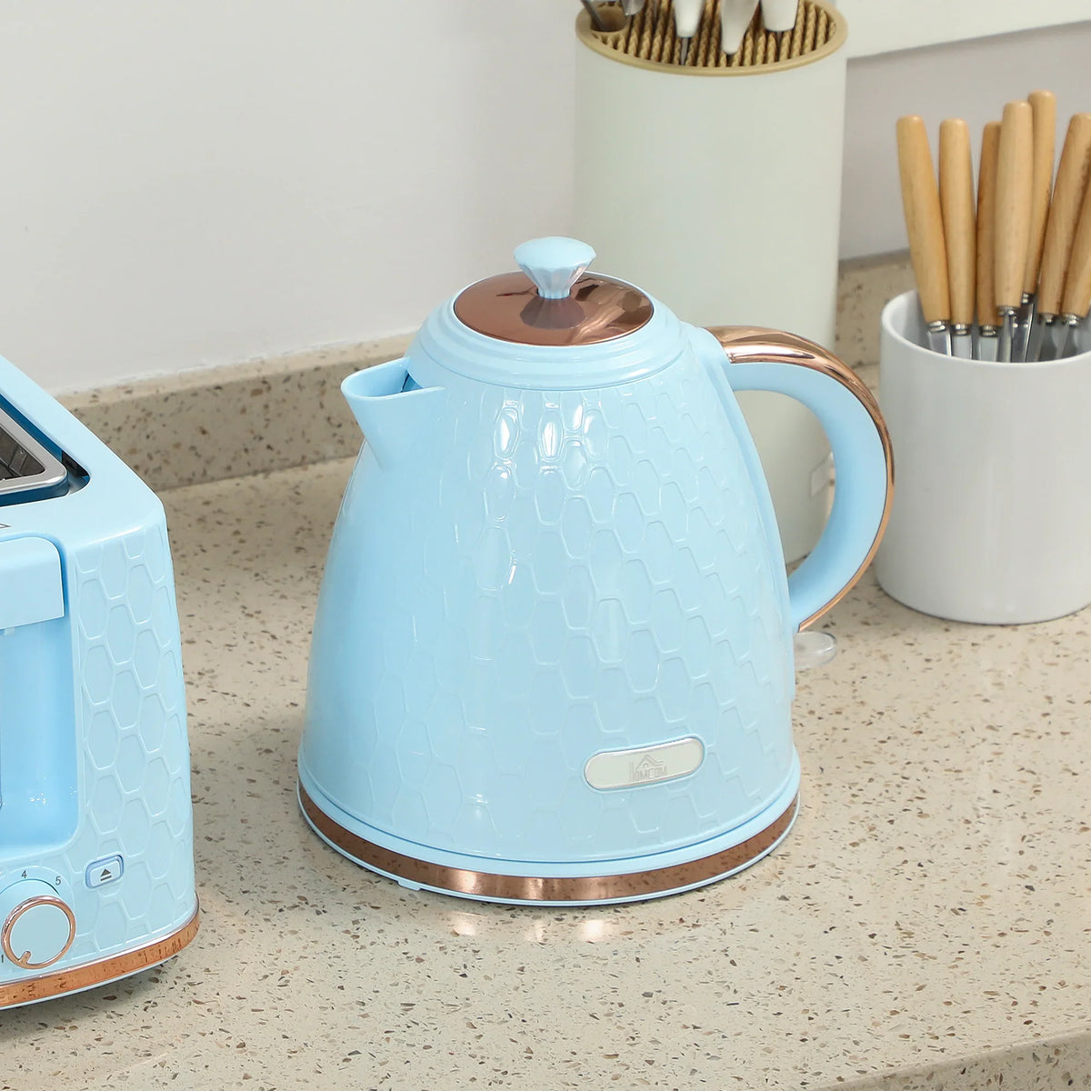 Light blue electric kettle with copper-toned base ring and curved carrying handle
