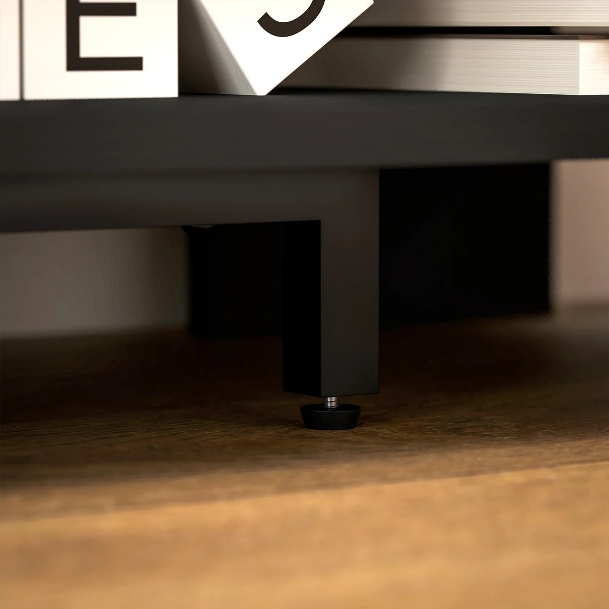 Black corner TV stand leg and underside support under open shelving
