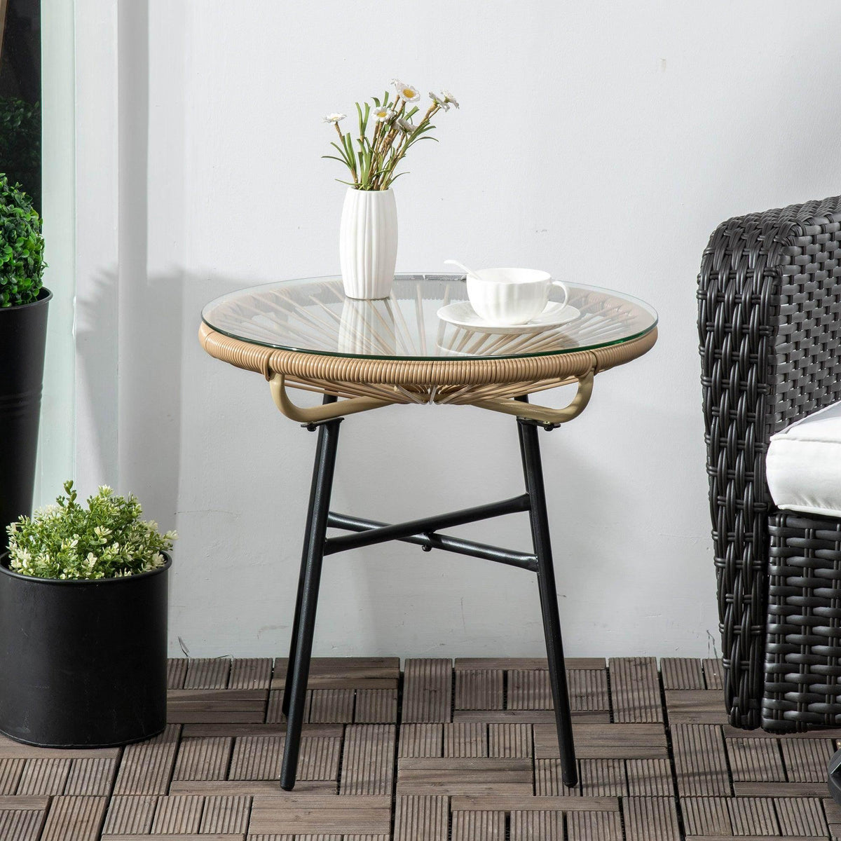 Rattan side table with round glass top and curved rattan apron on black legs