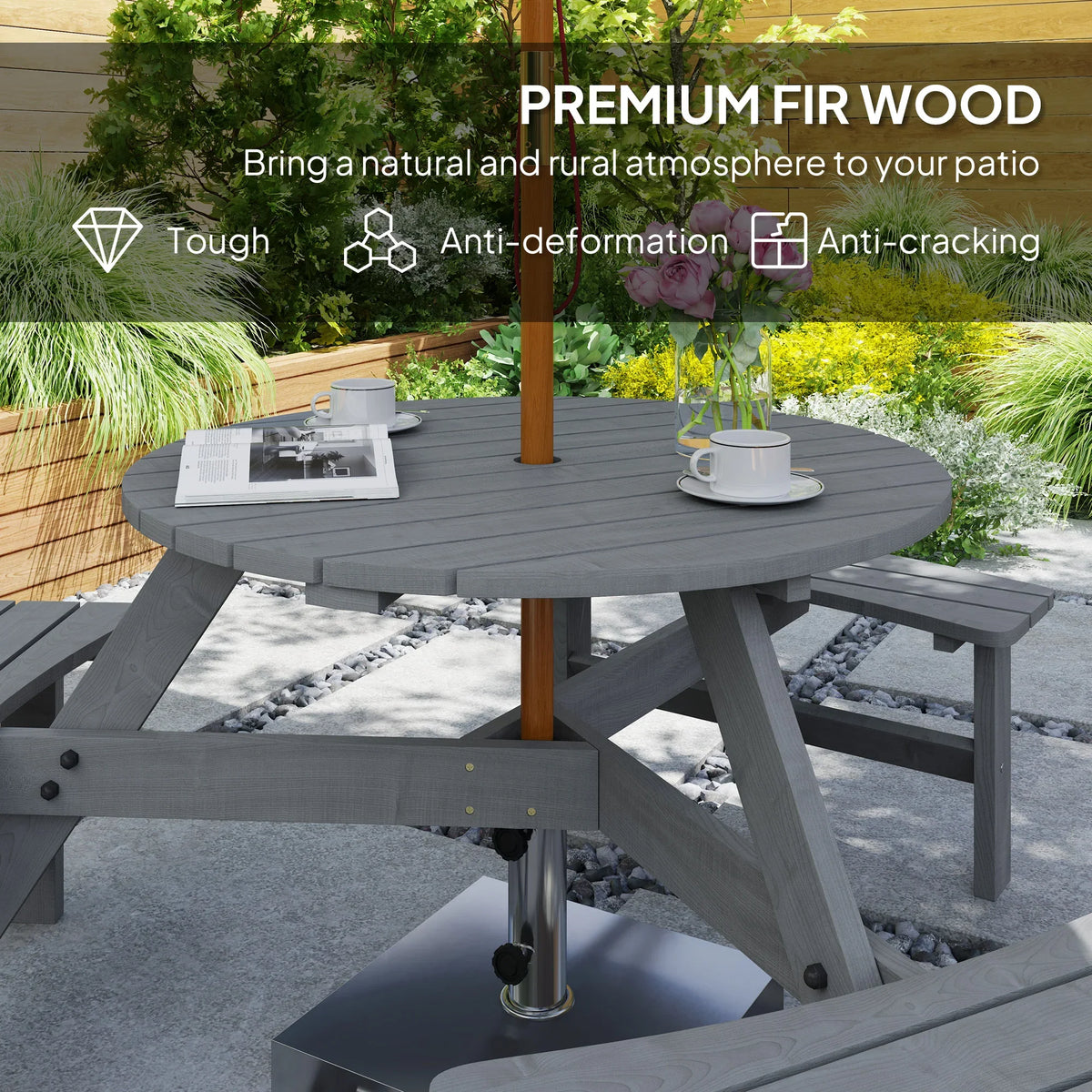 Grey wooden outdoor dining table set with two benches around a round slatted tabletop