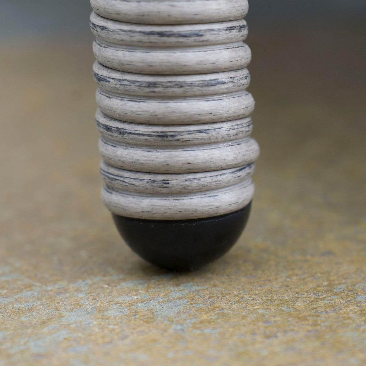 Woven rattan furniture leg with rounded gray base