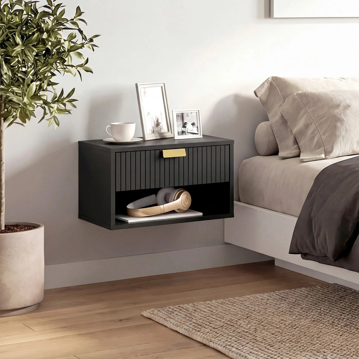 Black wall-mounted nightstand with fluted drawer front and open shelf for items