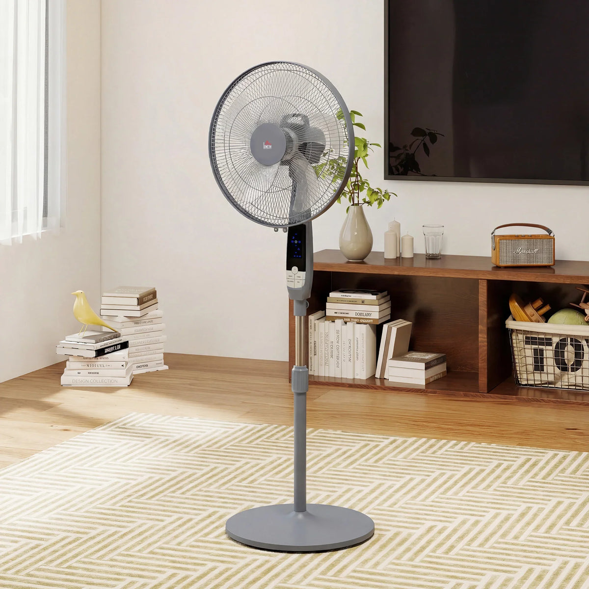 Grey pedestal floor fan with circular mesh grille standing on a patterned rug