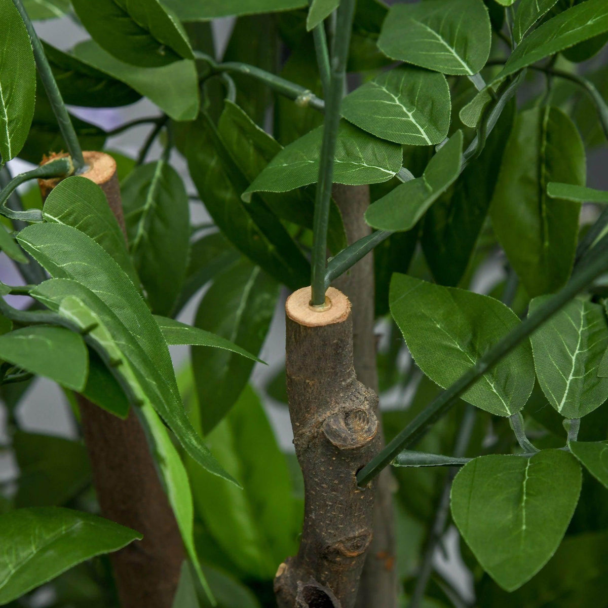 Artificial wisteria trunk detail with dark bark texture and green leaf clusters