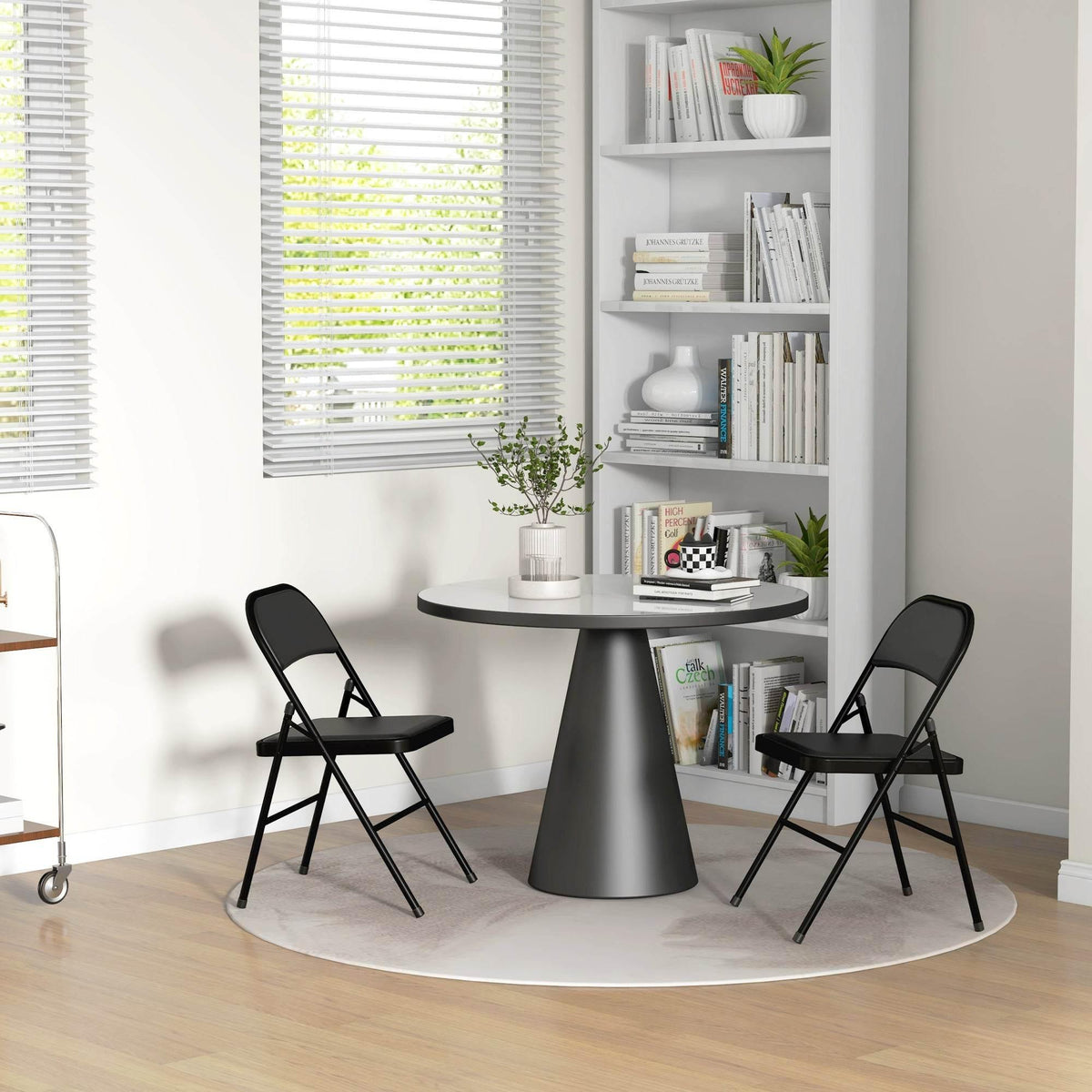 Pair of black folding chairs with padded seats and backs, for compact dining