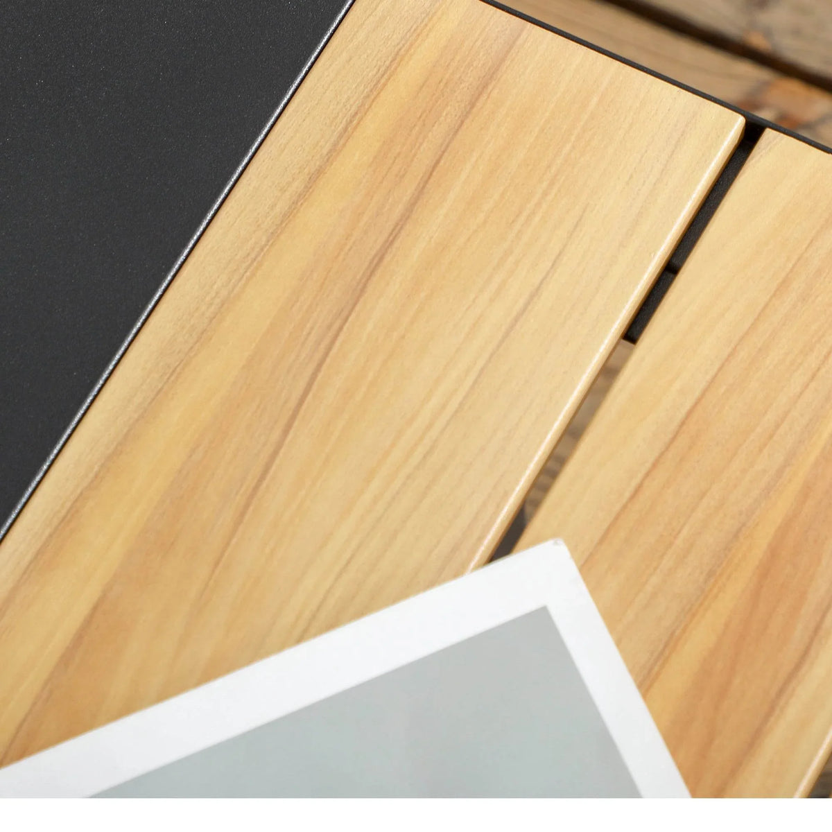 Wood tabletop with dark grey frame on an outdoor side table