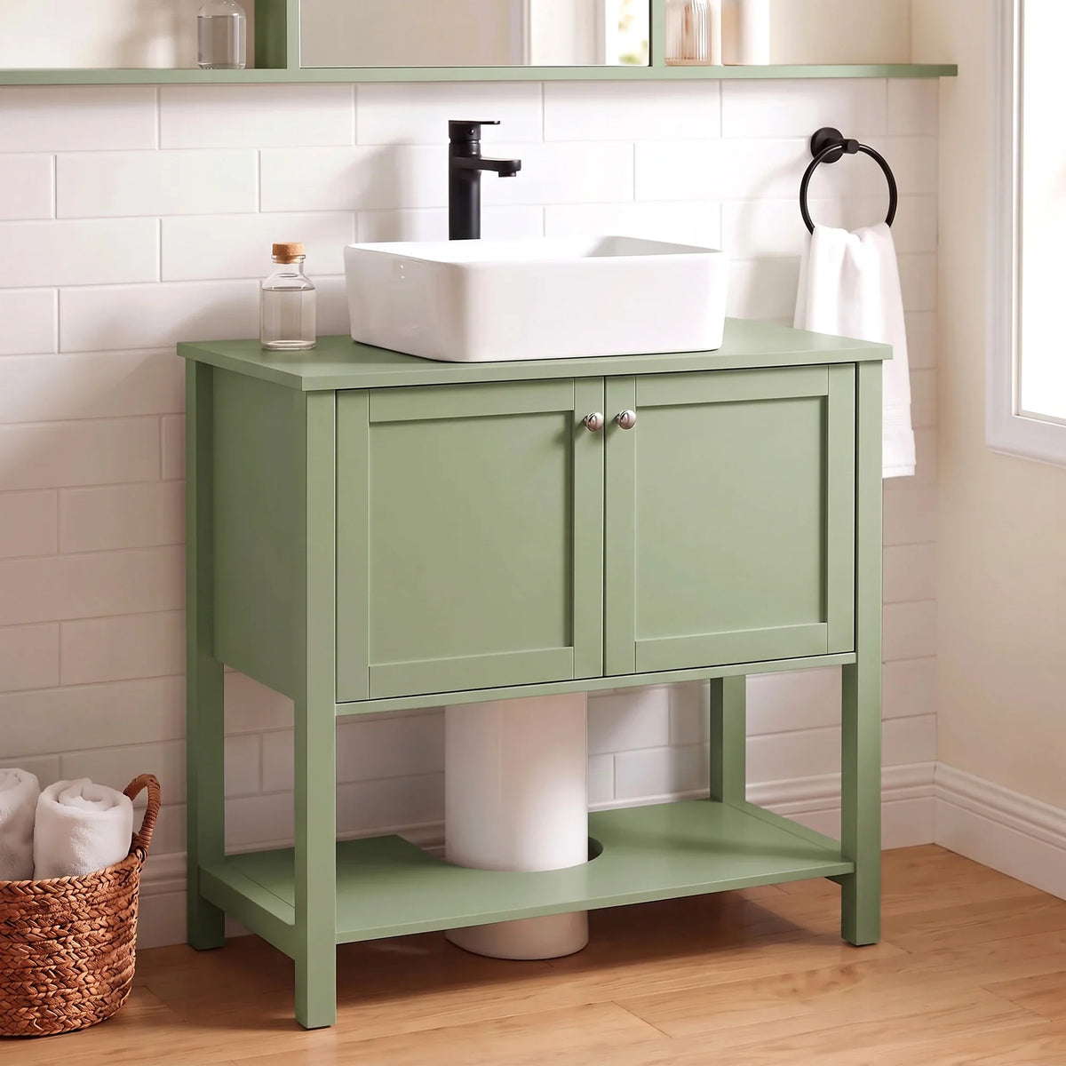 Green under-sink bathroom cabinet with two doors and open shelf beneath.