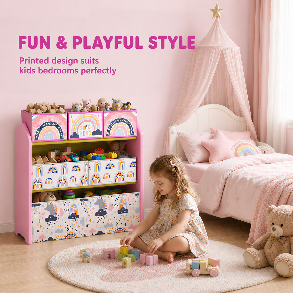 Pink kids toy storage rack with fabric bins and rainbow print, child playing on rug