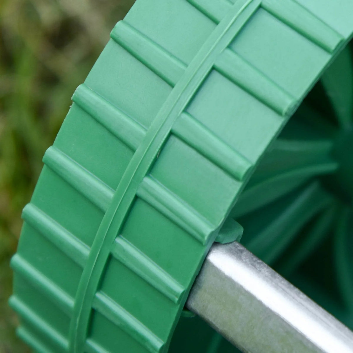 Green guard and silver shaft section of a lawn aerator