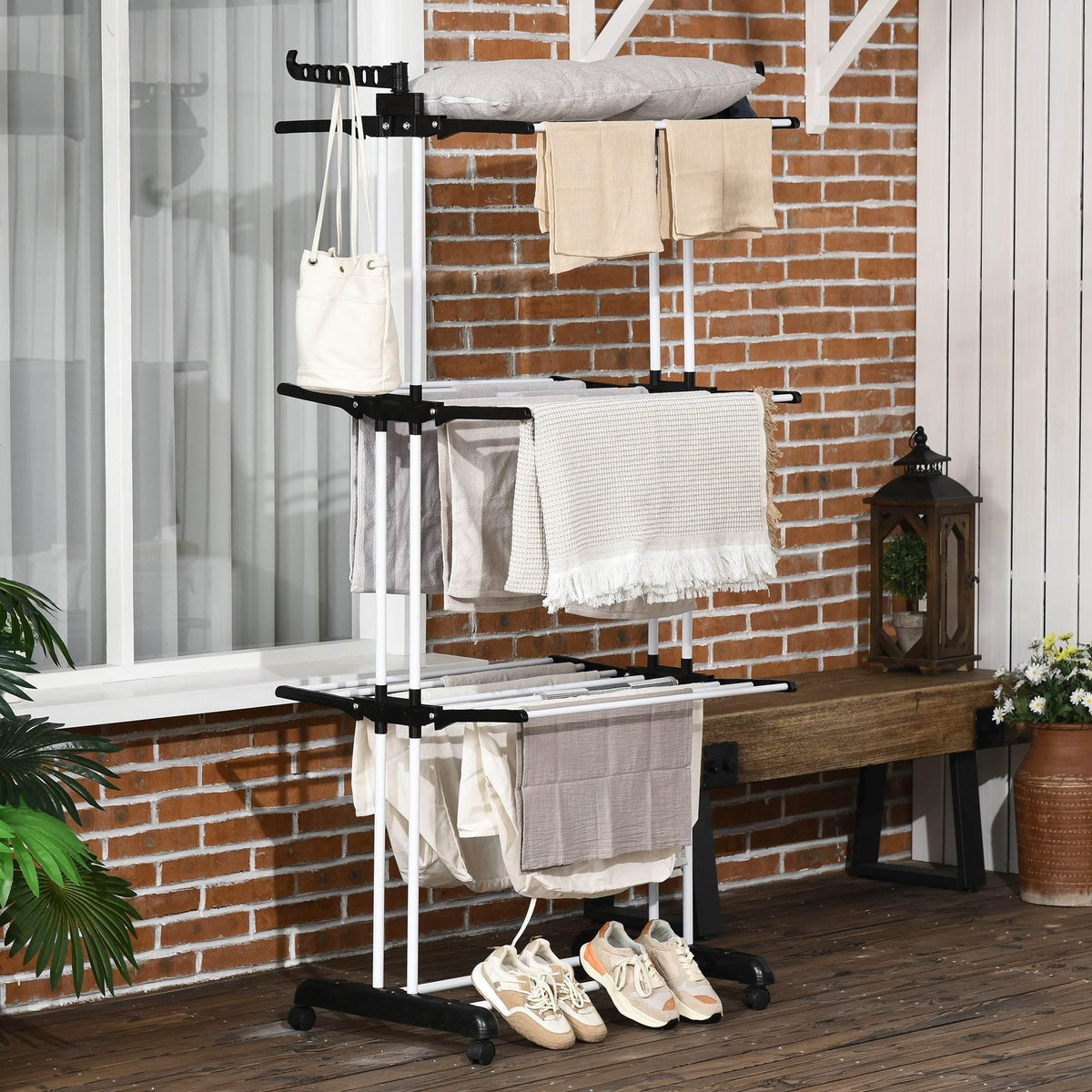Black 4-tier laundry drying rack with side bars, wheels, and hanging clothes