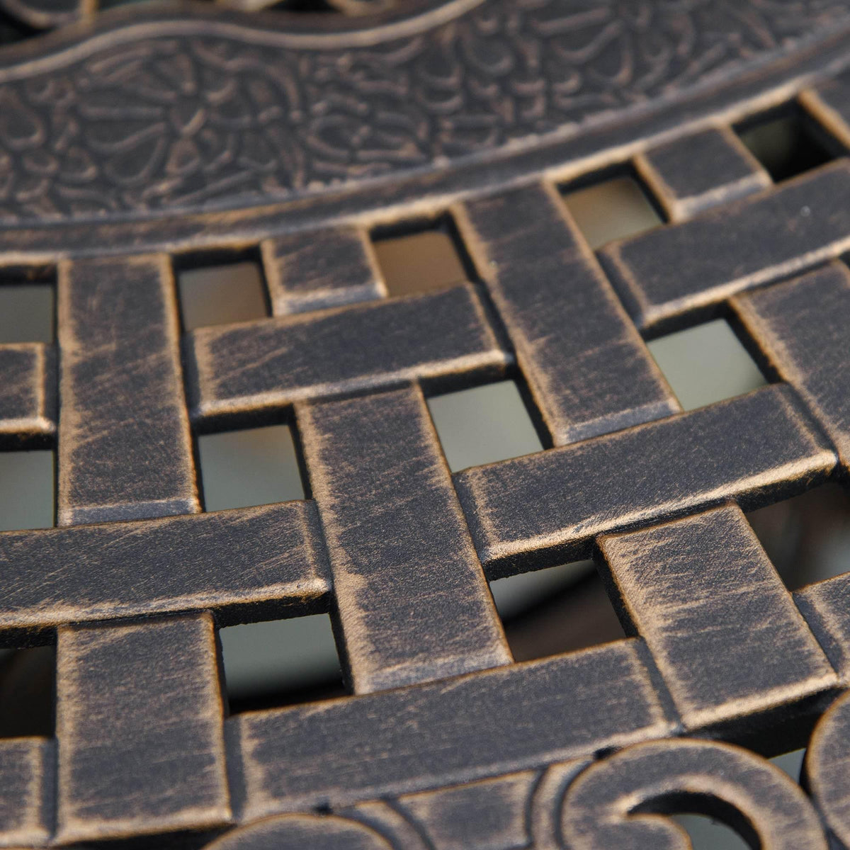Close-up of bronze lattice tabletop pattern with cross and scroll details
