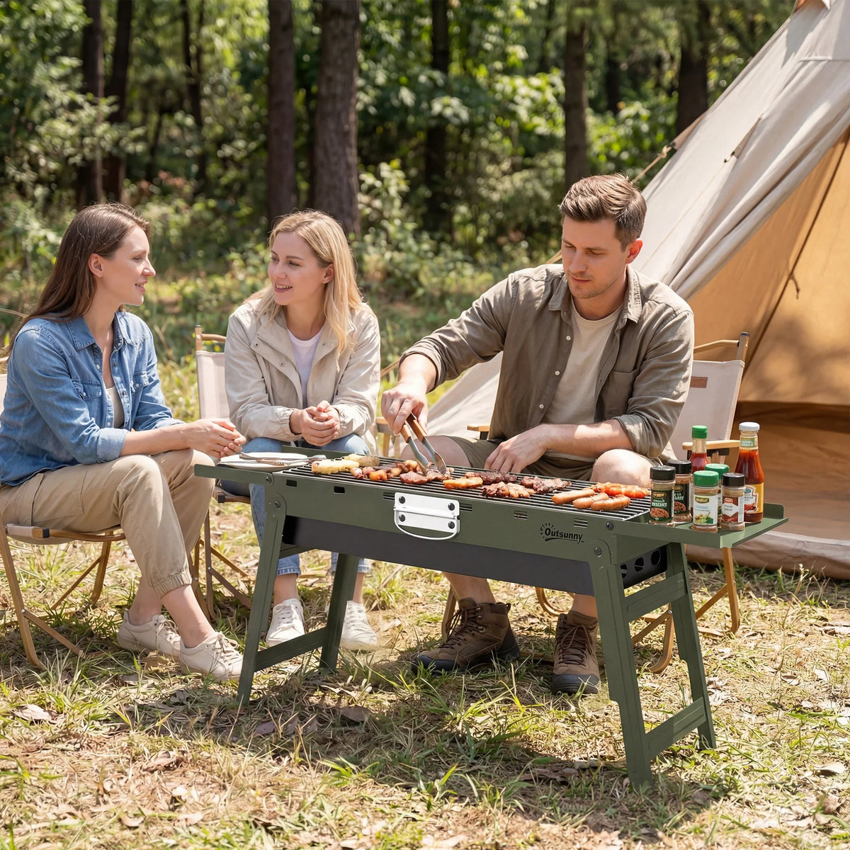 Green camping BBQ grill with side shelves and cooking grate during outdoor meal setup