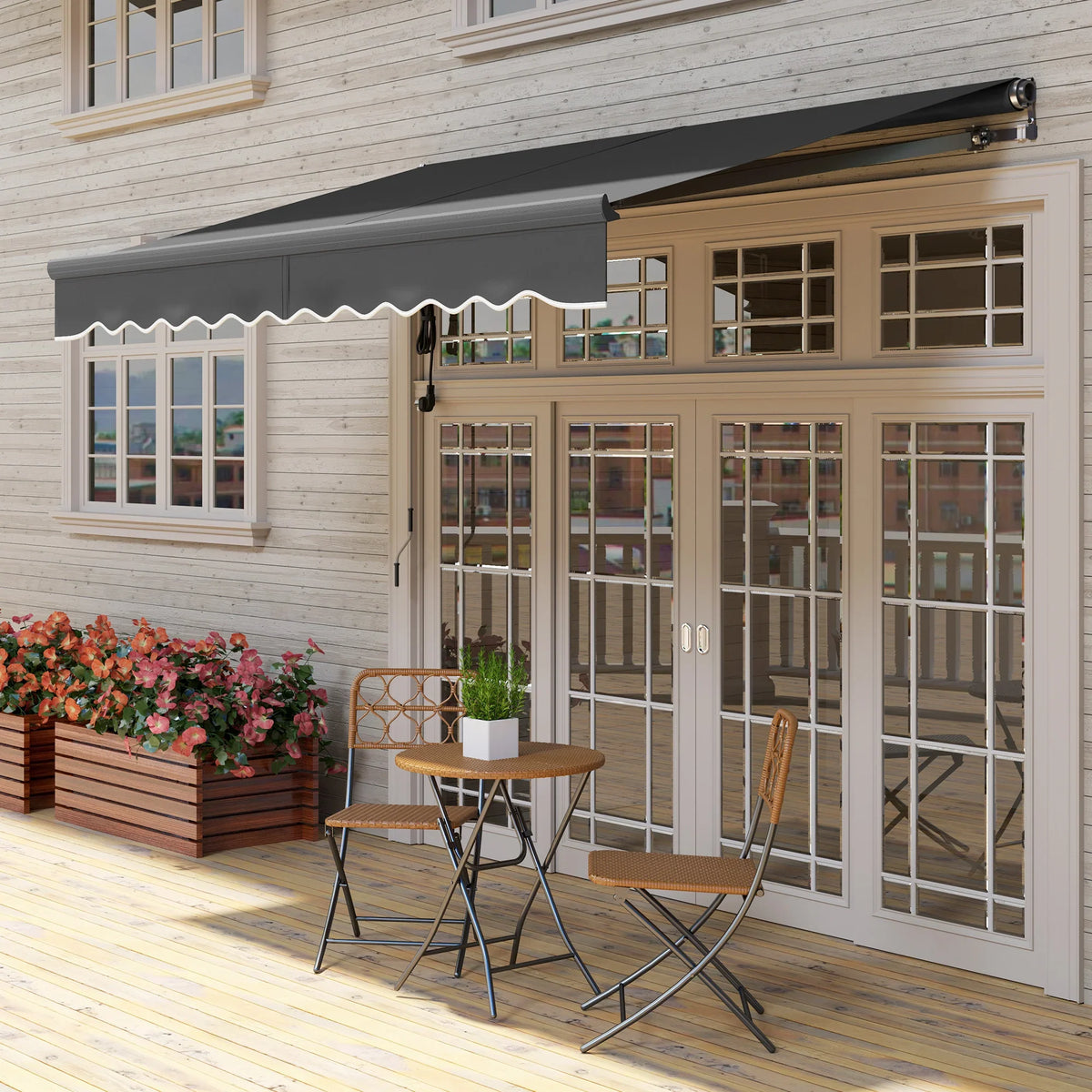 Electric retractable awning with dark gray fabric canopy over patio table and chairs