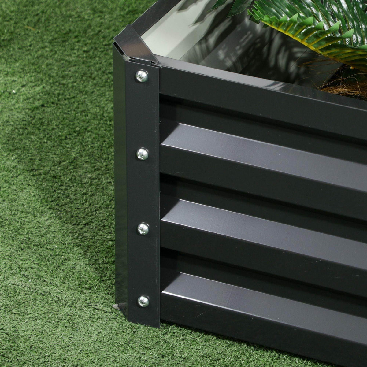 Dark gray raised garden bed side panel corner with riveted metal slats and bolts