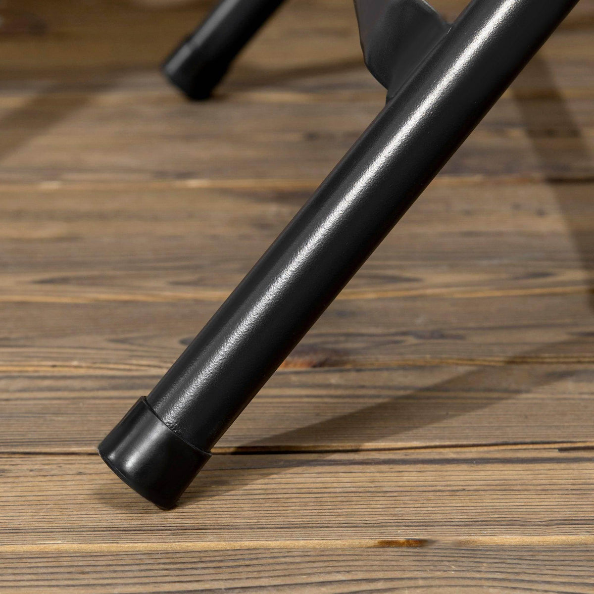 Black metal leg of a foldable outdoor dining table with rounded foot