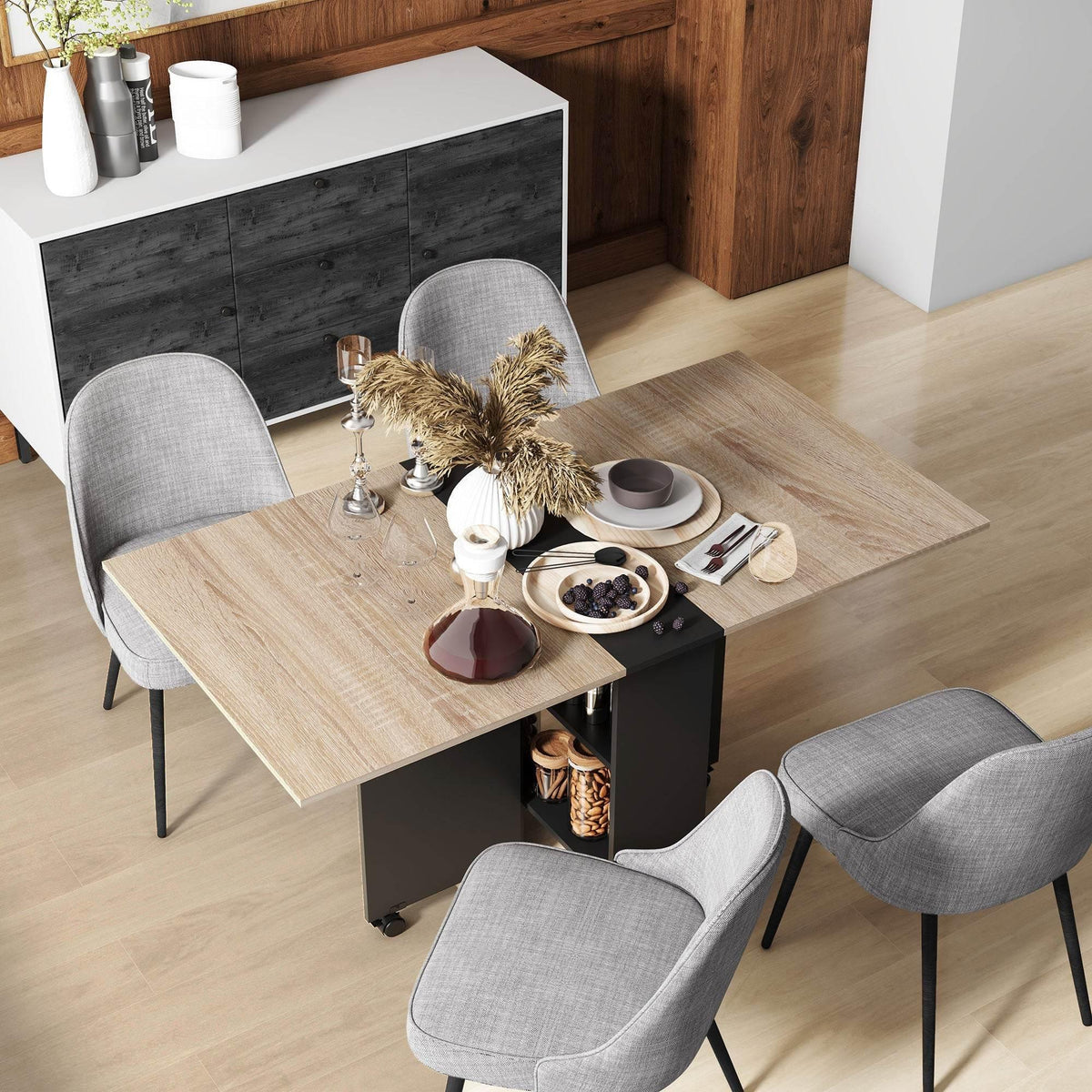 Drop-leaf dining table with light oak top, dark base, and rolling storage shelves