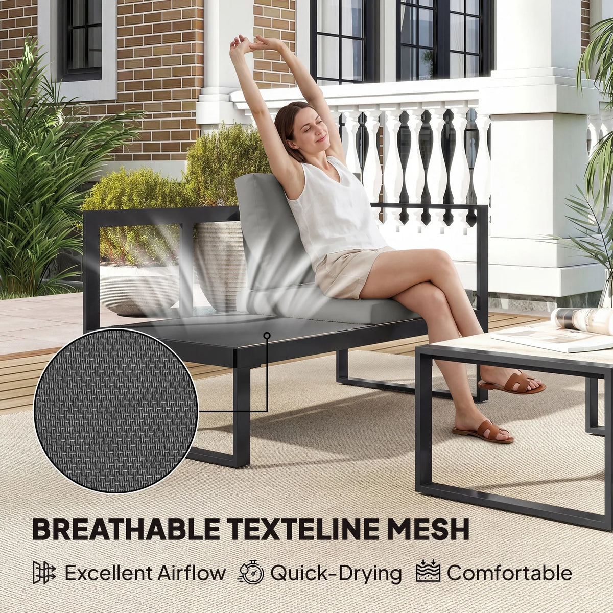 Dark grey outdoor loveseat with textured mesh back and black frame plus coffee table