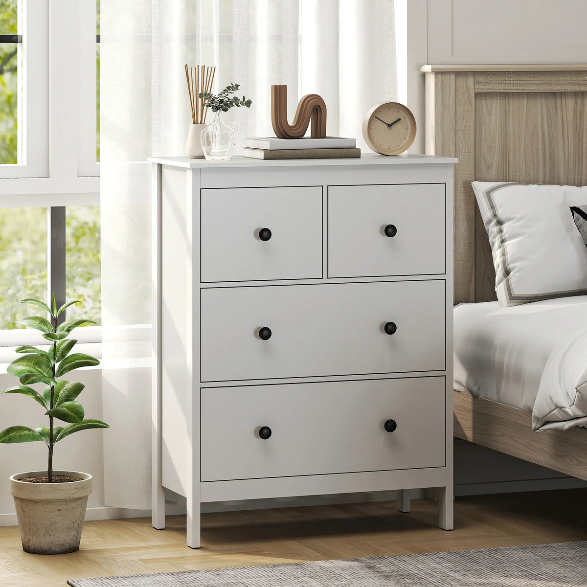 White 4-drawer chest of drawers with black knobs and a flat top