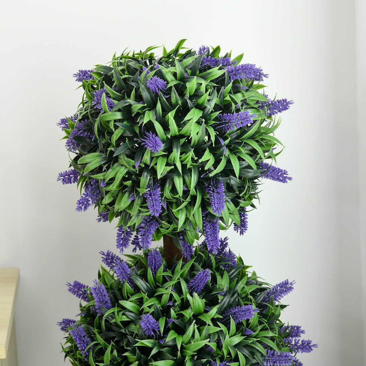 Close-up of an artificial ball tree plant with green leaves and purple lavender flowers