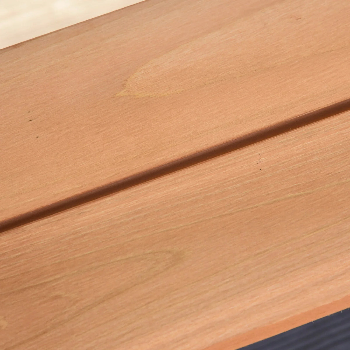 Brown wooden tabletop surface with smooth edge and visible wood grain, close-up