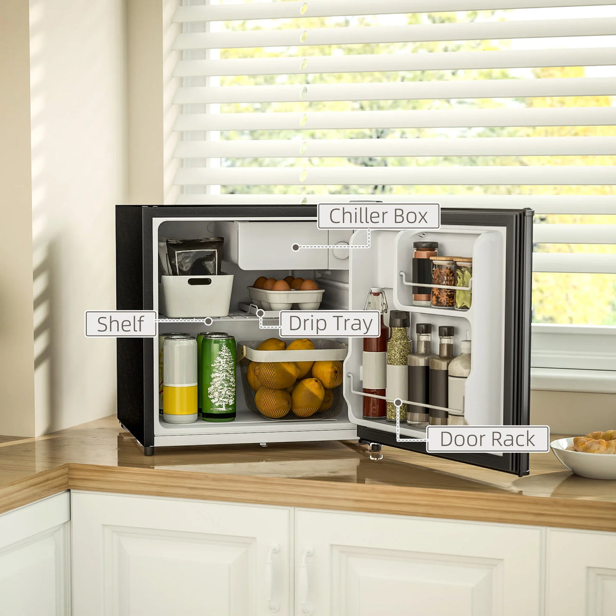 Black countertop mini fridge with open door, interior shelves, drip tray, and racks