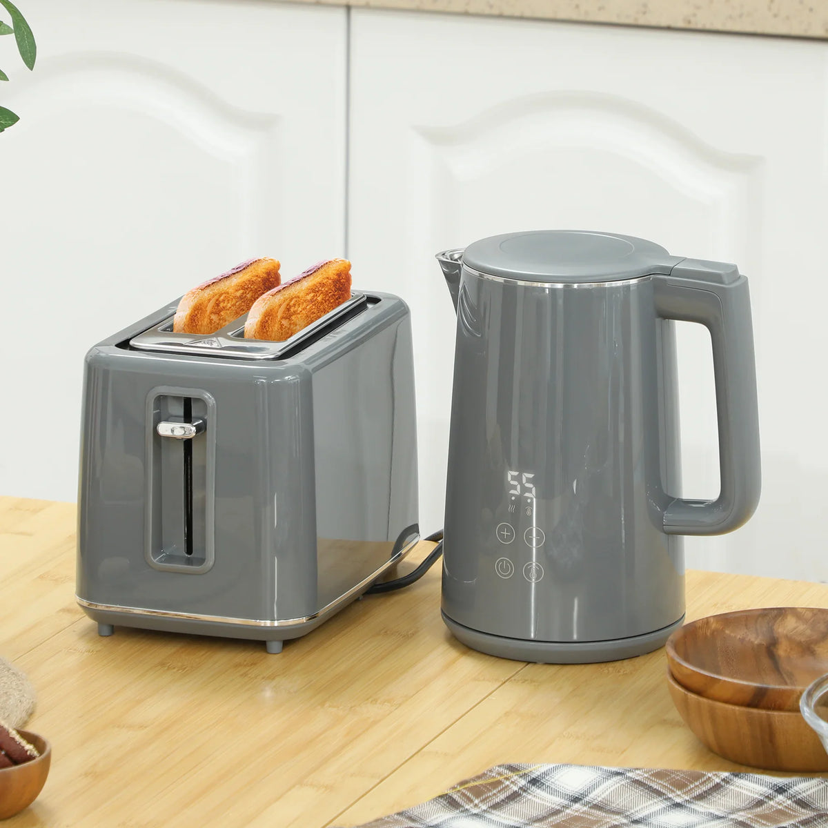 Grey 2-slice toaster and stainless kettle on wooden counter