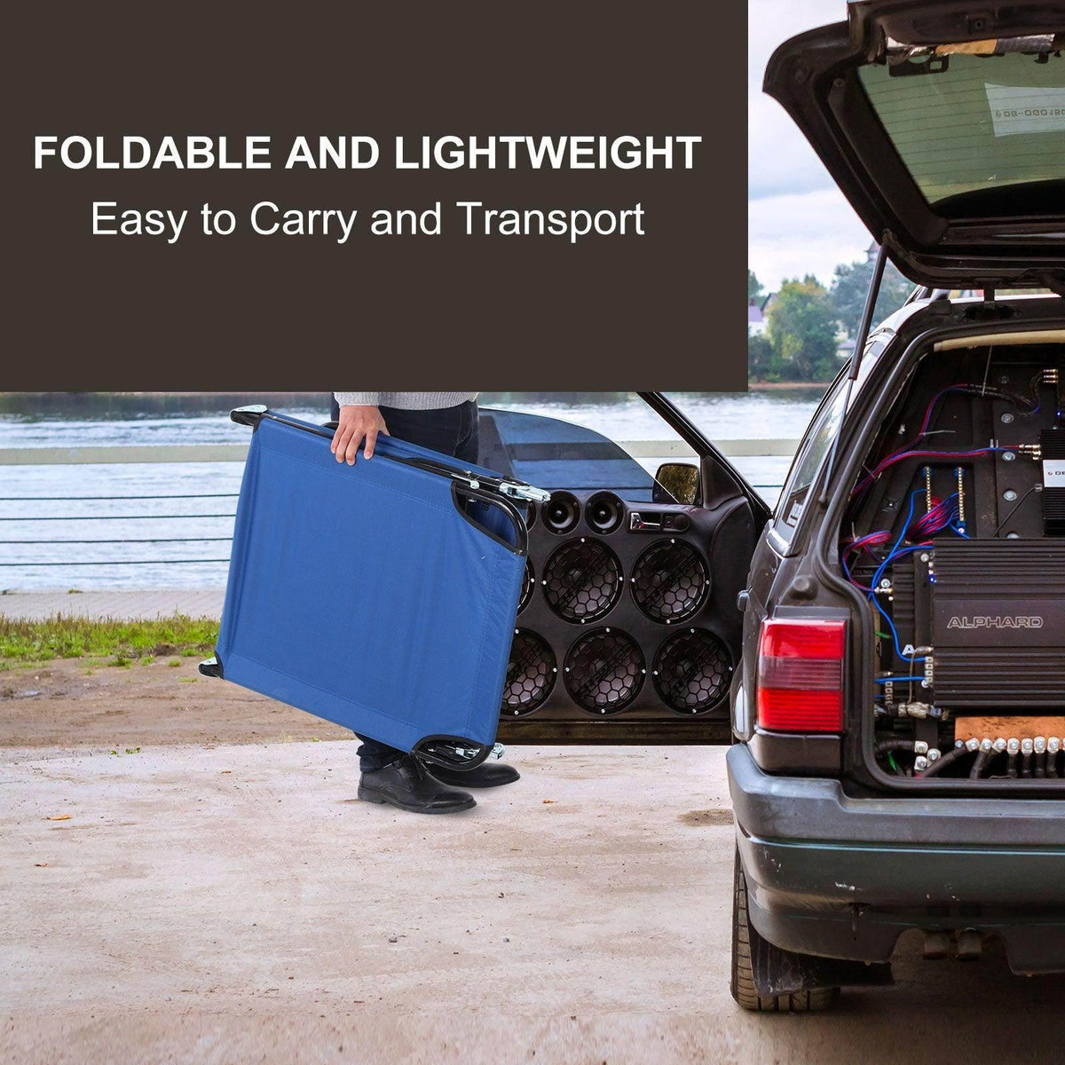 Blue foldable sun lounger carried by handle, compact for transport near a car