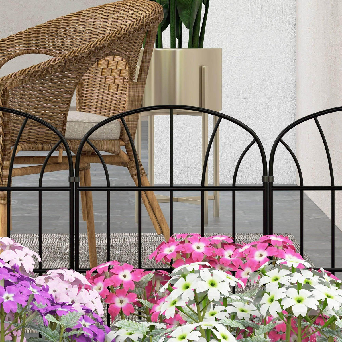 Black metal decorative fence panel in front of patio chairs and potted plants