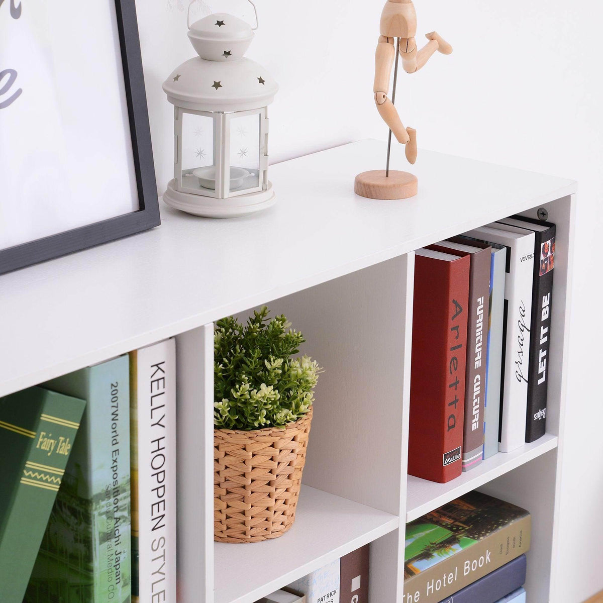 White cube storage cabinet with open cubbies and books beside a woven basket