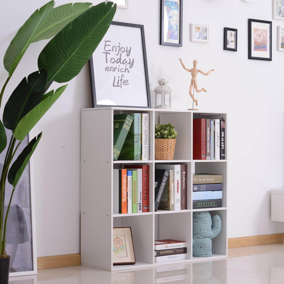 White 9-cube storage cabinet with open cubbies filled with books and decor