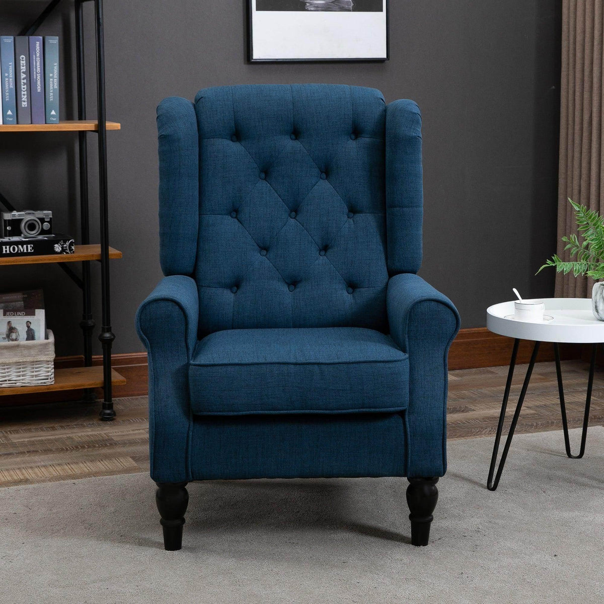 Blue tufted accent armchair with wing backrest, rolled arms, turned legs