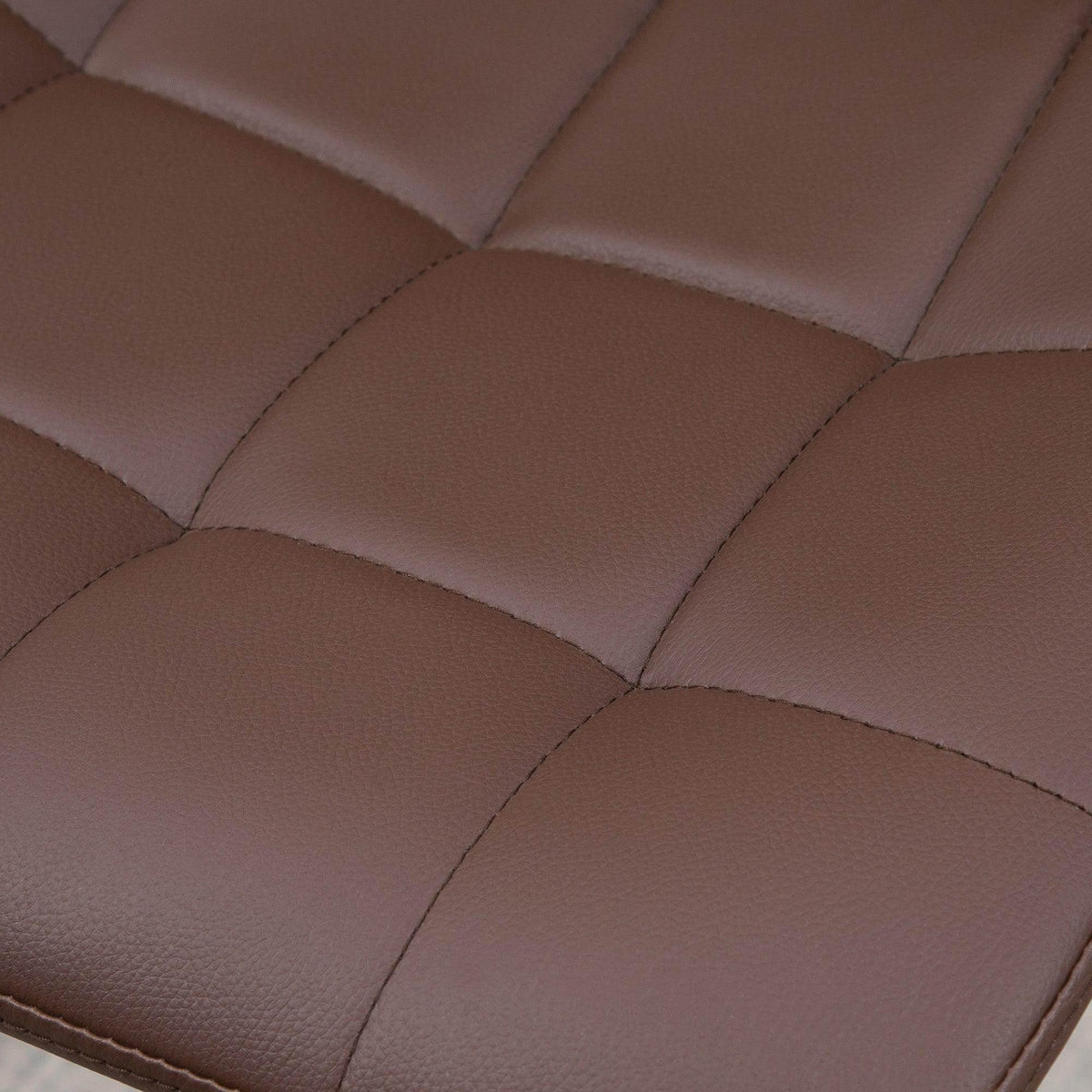 Close-up of brown quilted PU seat padding with stitched seams on bar stool