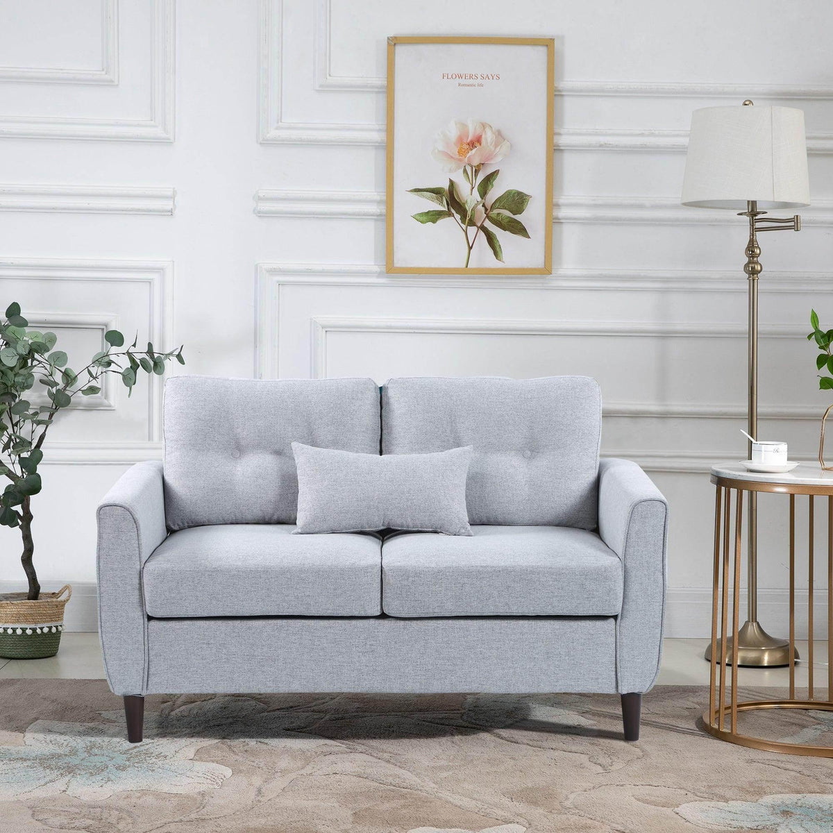 Light grey upholstered loveseat with tufted back, two throw pillows, and wooden legs
