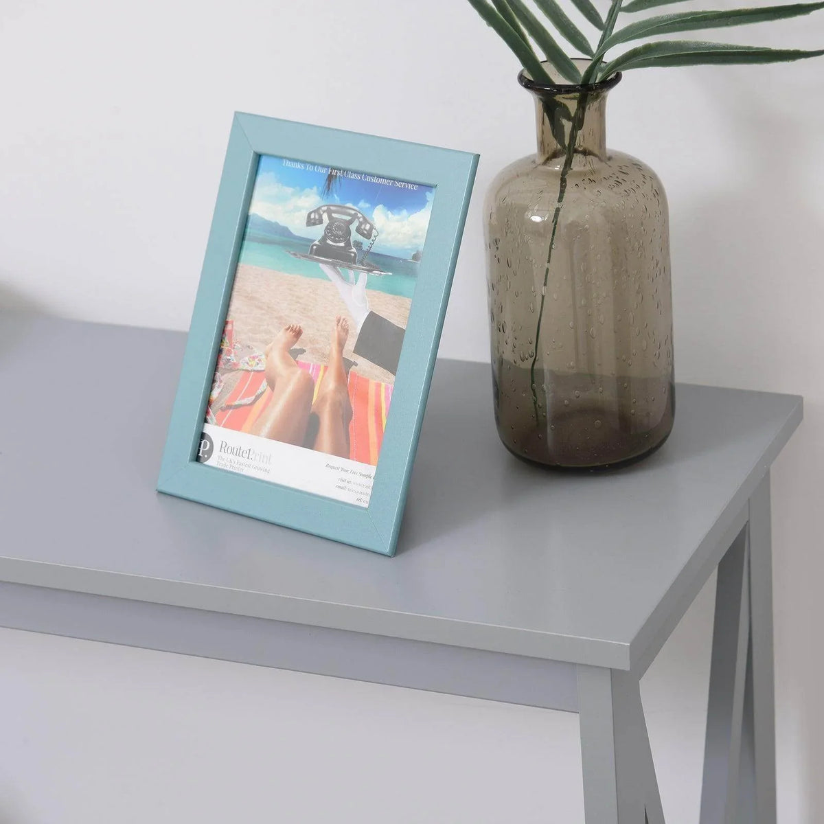Grey console table tabletop with photo frame and vase beside the open shelf