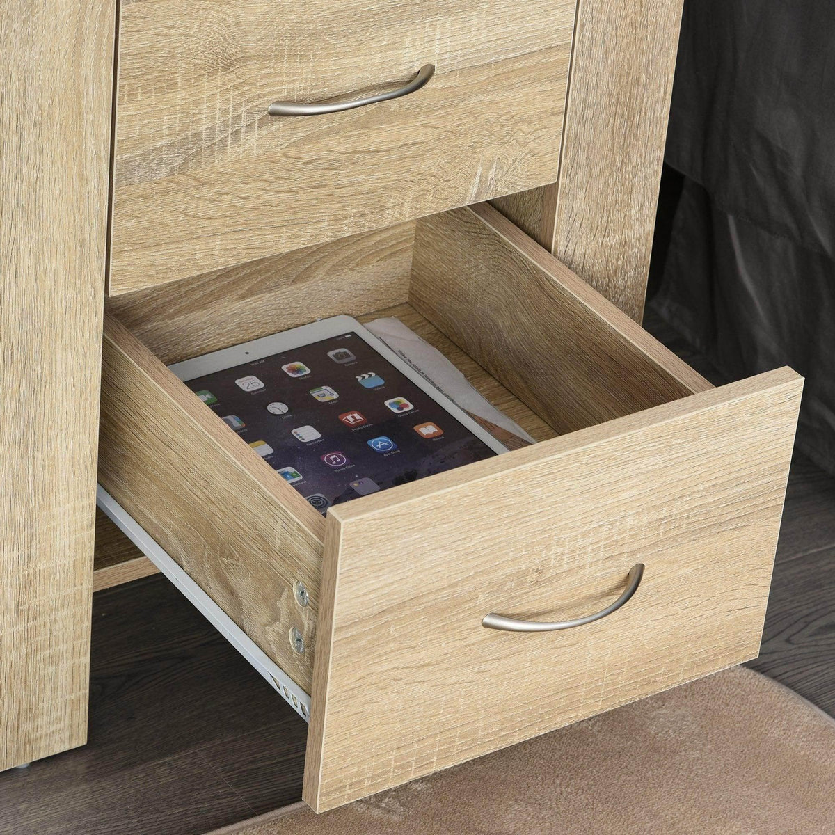Light oak nightstand drawer pulled open, showing space for a tablet.