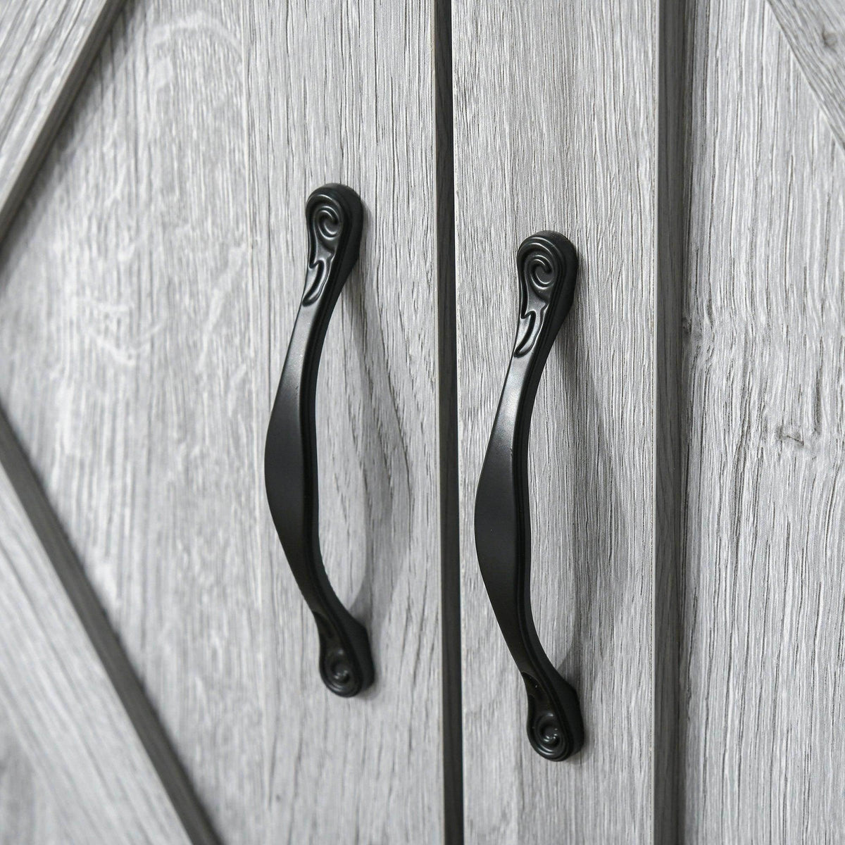 Pair of black metal curved handles on grey X-panel sideboard doors