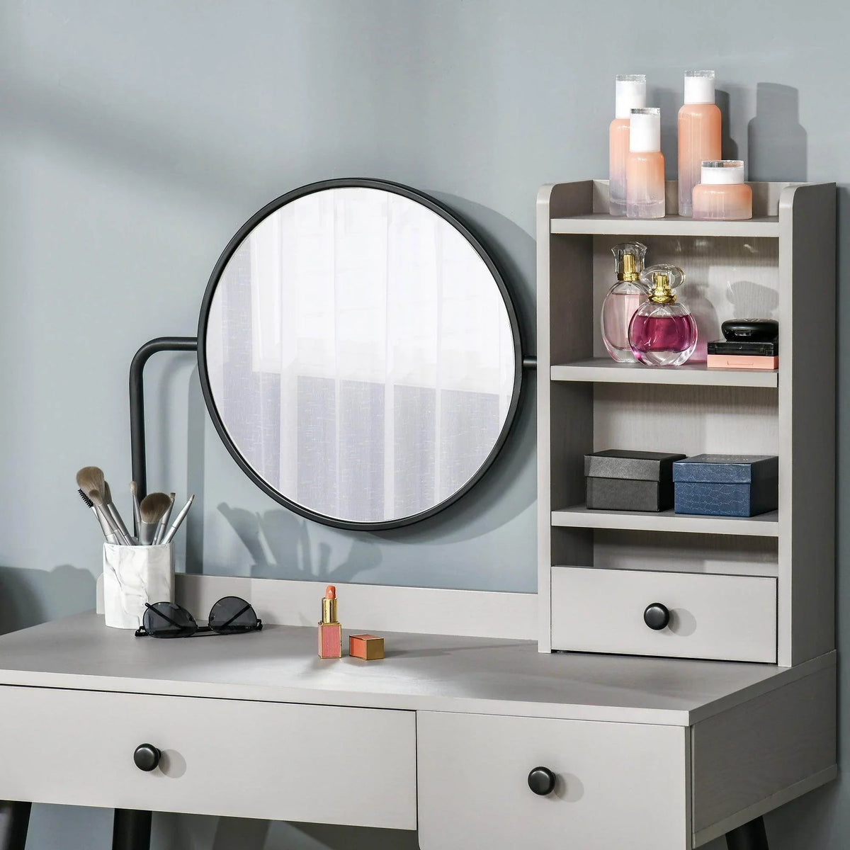 Grey dressing table with round mirror and open shelving cabinet with drawer