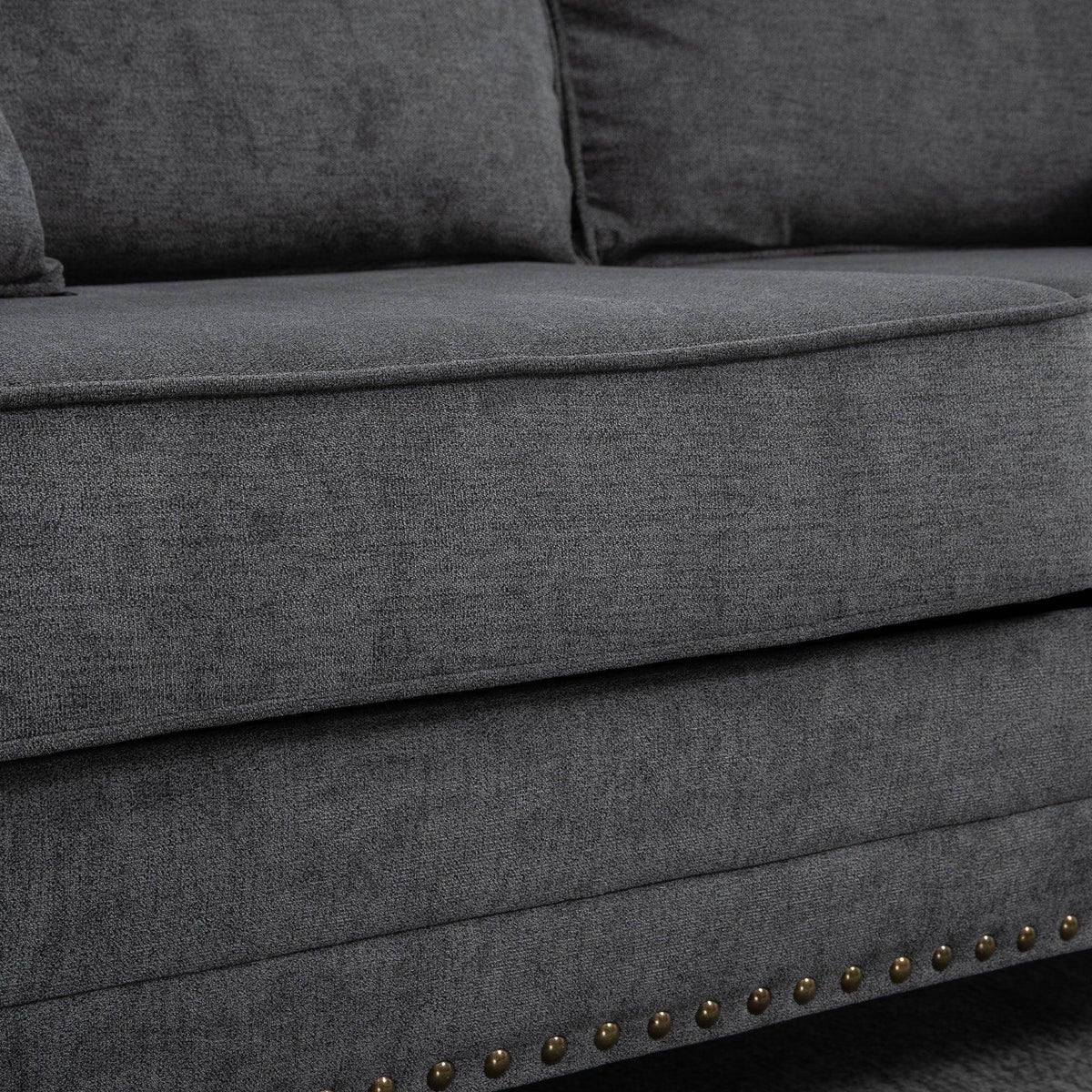 Gray loveseat seat and arm with stitched seams and nailhead-trim strip