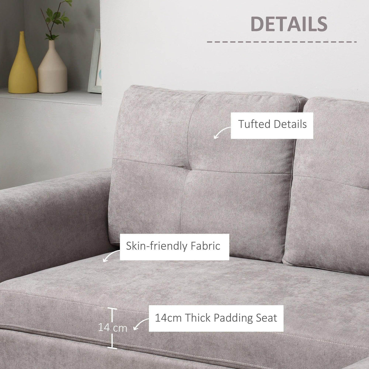 Grey upholstered sofa bed corner with tufted arms and thick padded seat