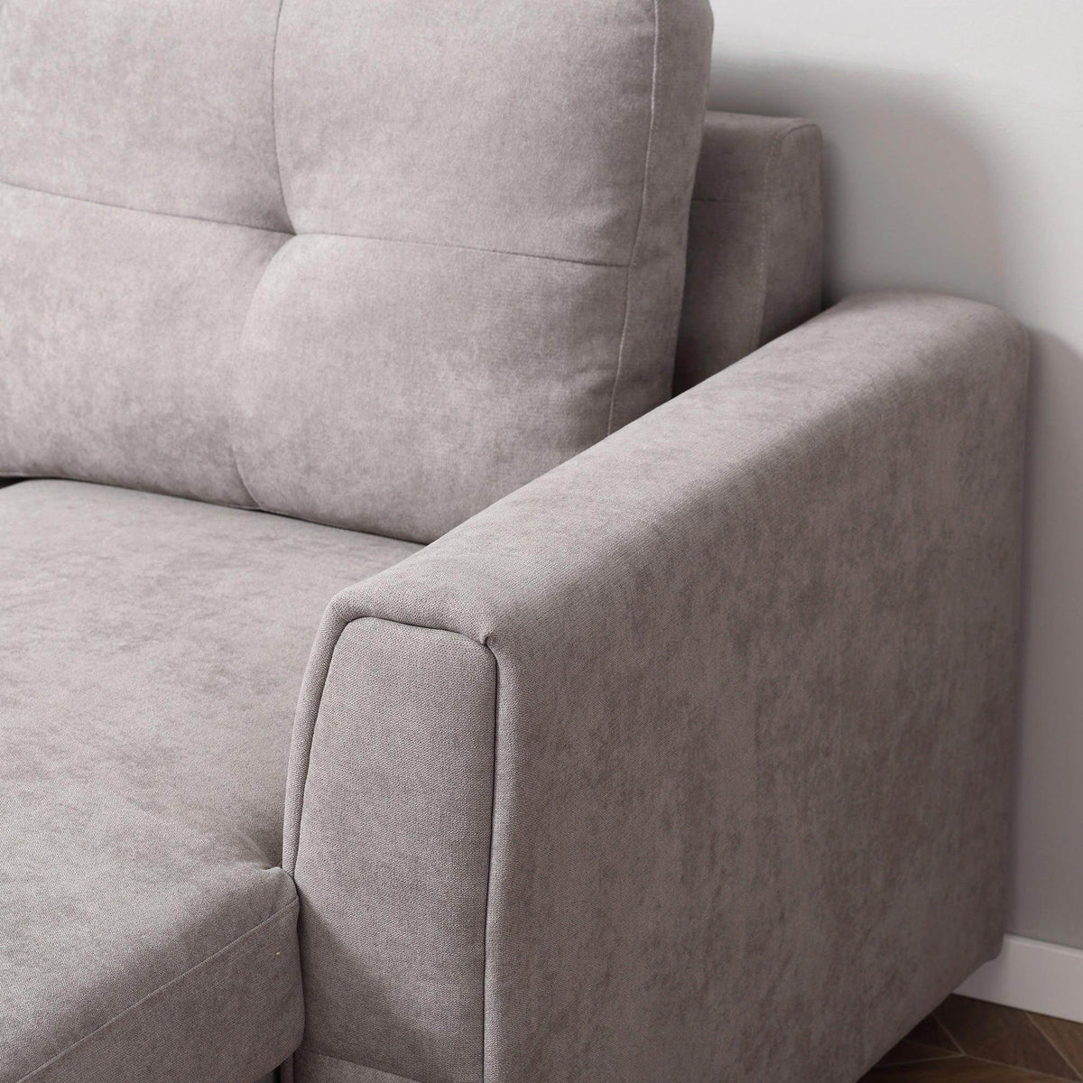 Grey chaise arm and seat corner of sofa bed with padded tufted back