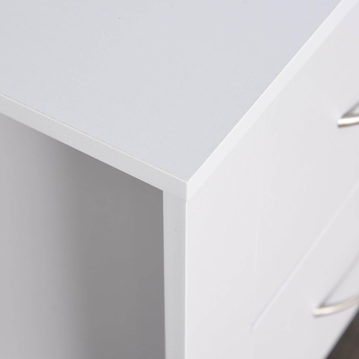 Corner view of white bedside table showing sturdy leg and drawer edge