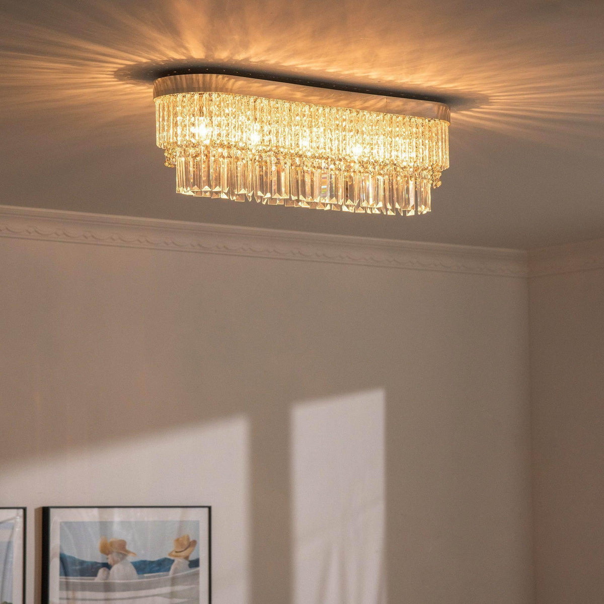 Warm gold crystal chandelier with cascading drops and round canopy mounted on ceiling.