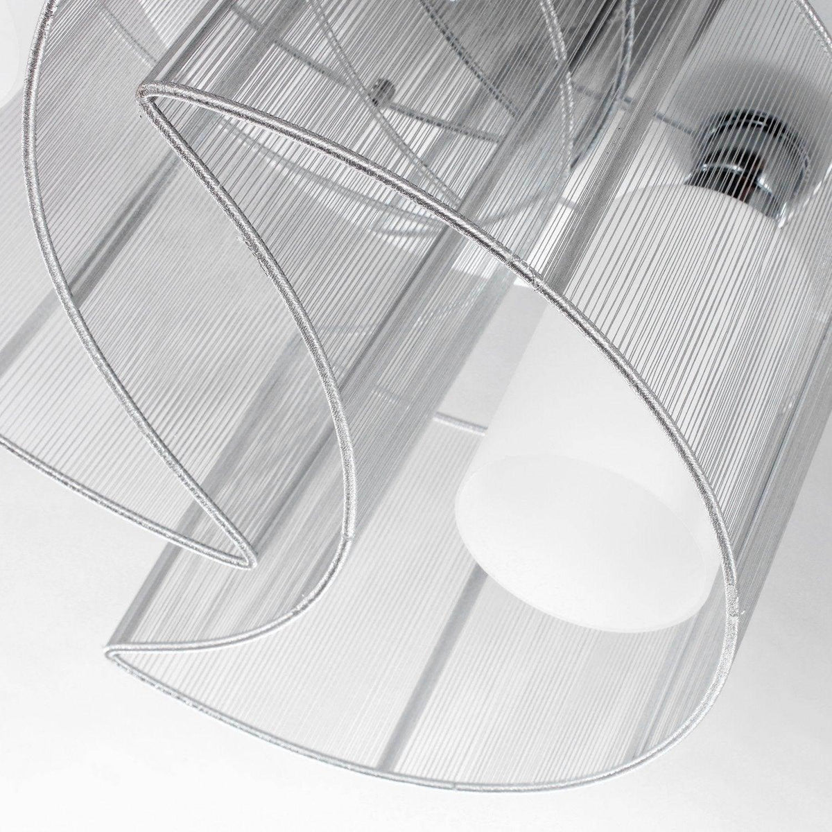 Close-up of chrome cage and clear glass shade with round white bulb element