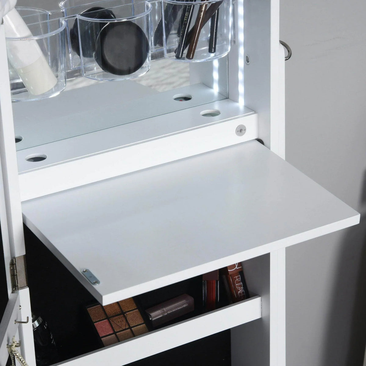 White jewelry storage armoire interior with drawer, shelf, and accessory holders