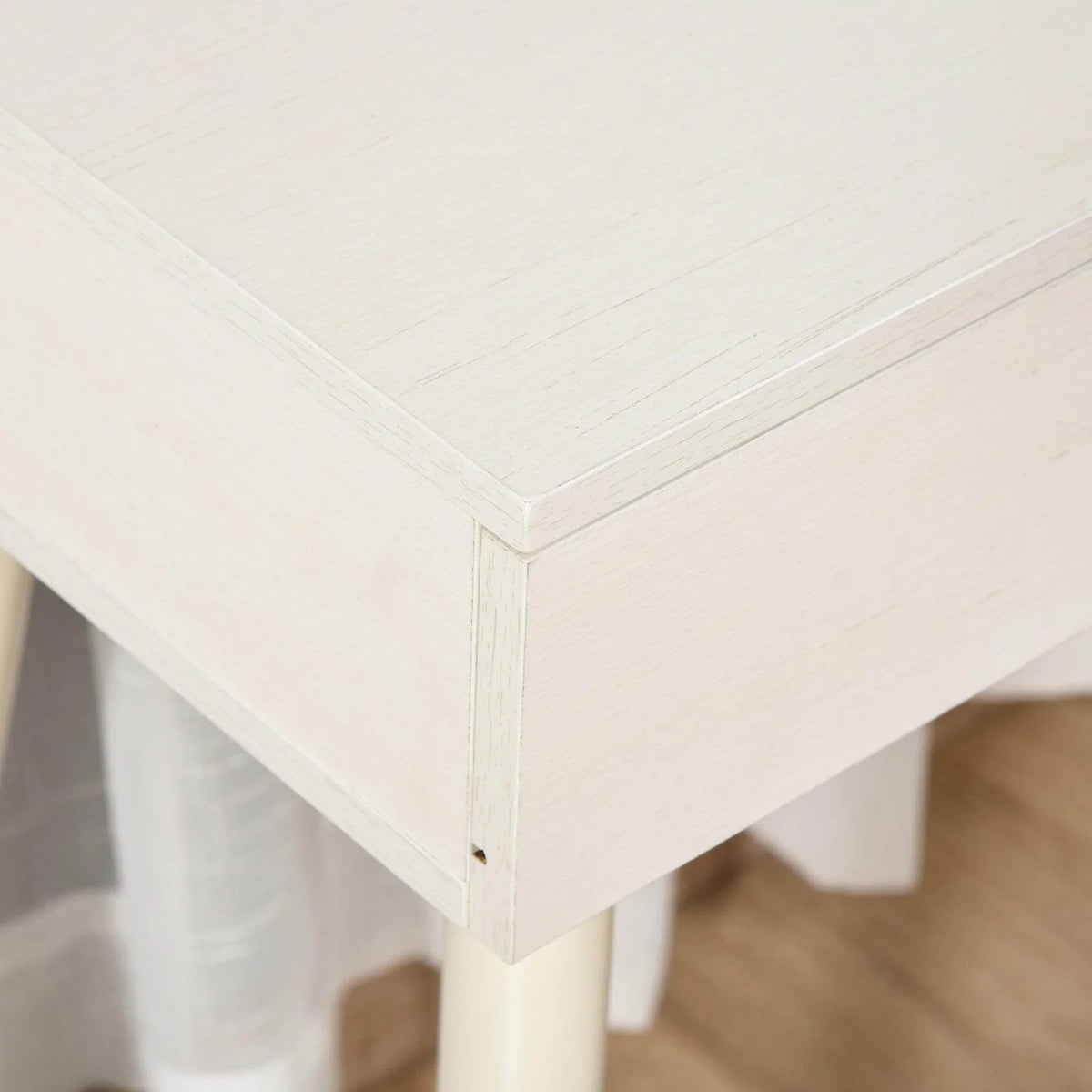 White vanity tabletop corner with clean panel edges and small hardware, close-up