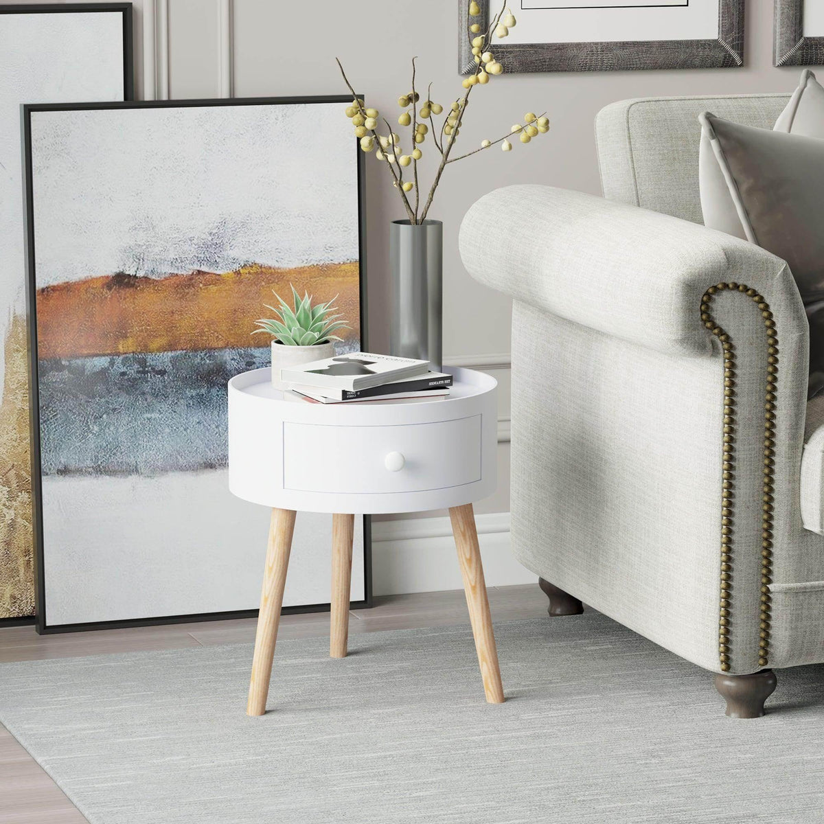 White round coffee table with drawer and light wood legs beside a sofa