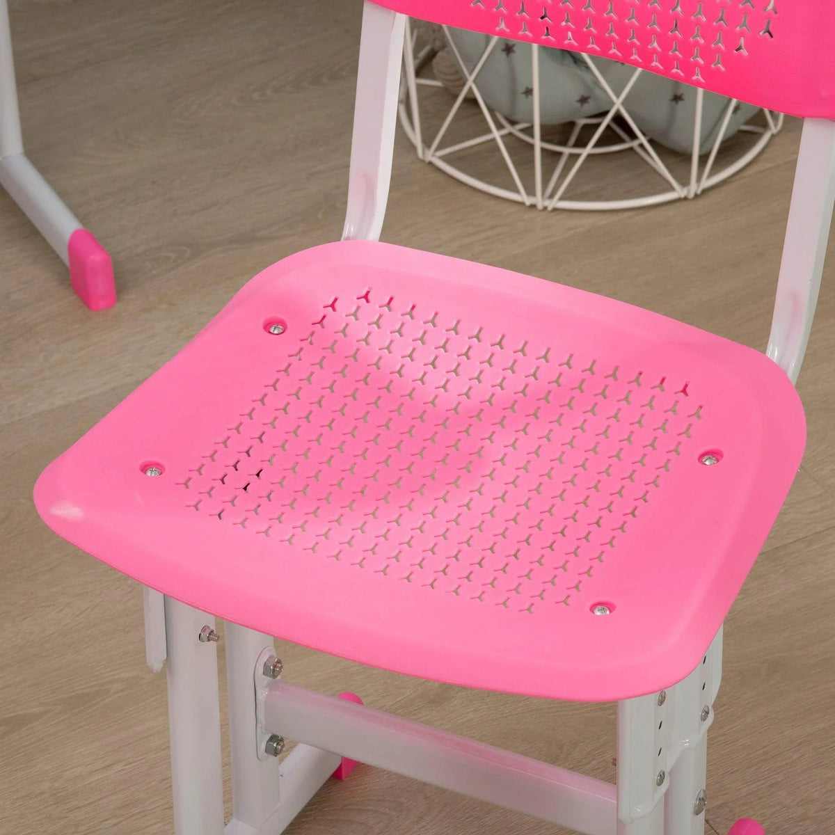 Pink chair seat with perforated pattern on a white kids desk set