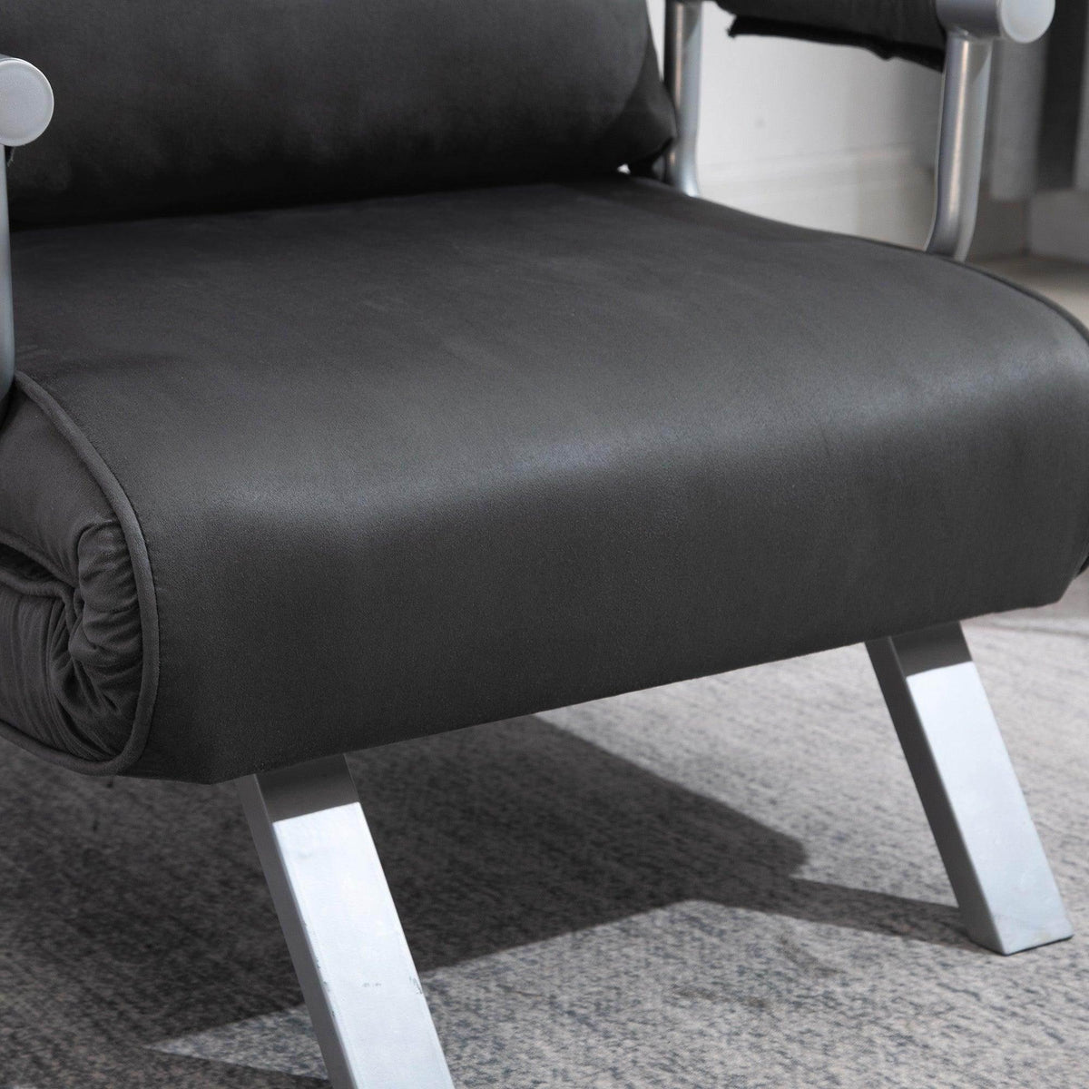 Portable armchair bed close-up of dark gray cushion with white metal legs and armrest