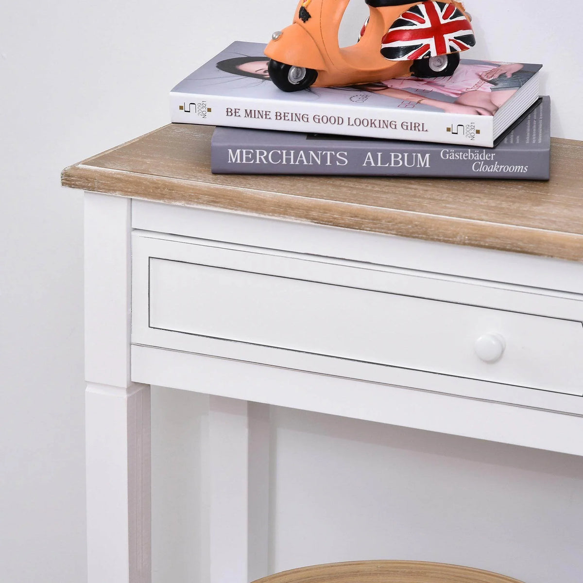White console table with tan tabletop and single drawer, styled with books on top